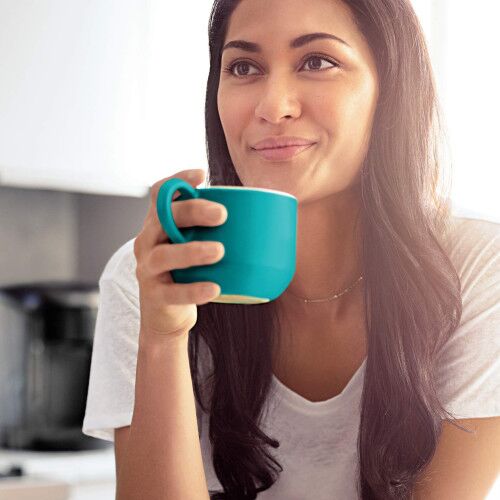 woman drinking from a blue mug in kitchen