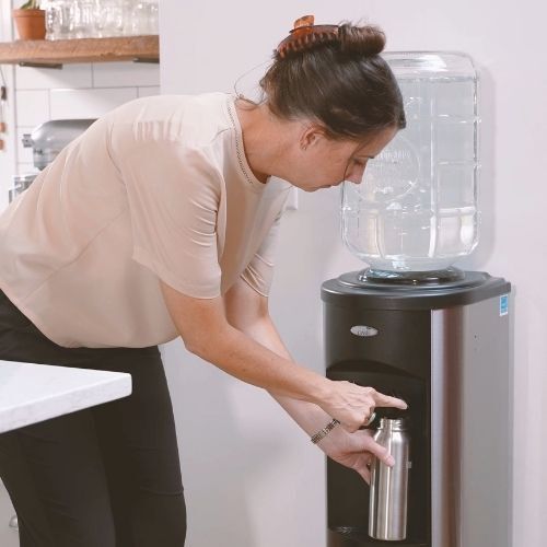 filling up water cooler with mountain valley bottle