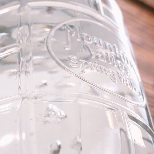 looking up at a glass Mountain Valley Spring Water bottle