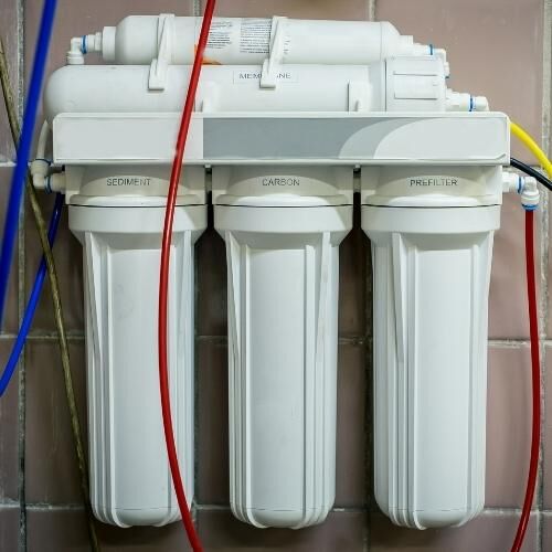 Water filtration system with sediment, carbon, and prefilter labels.